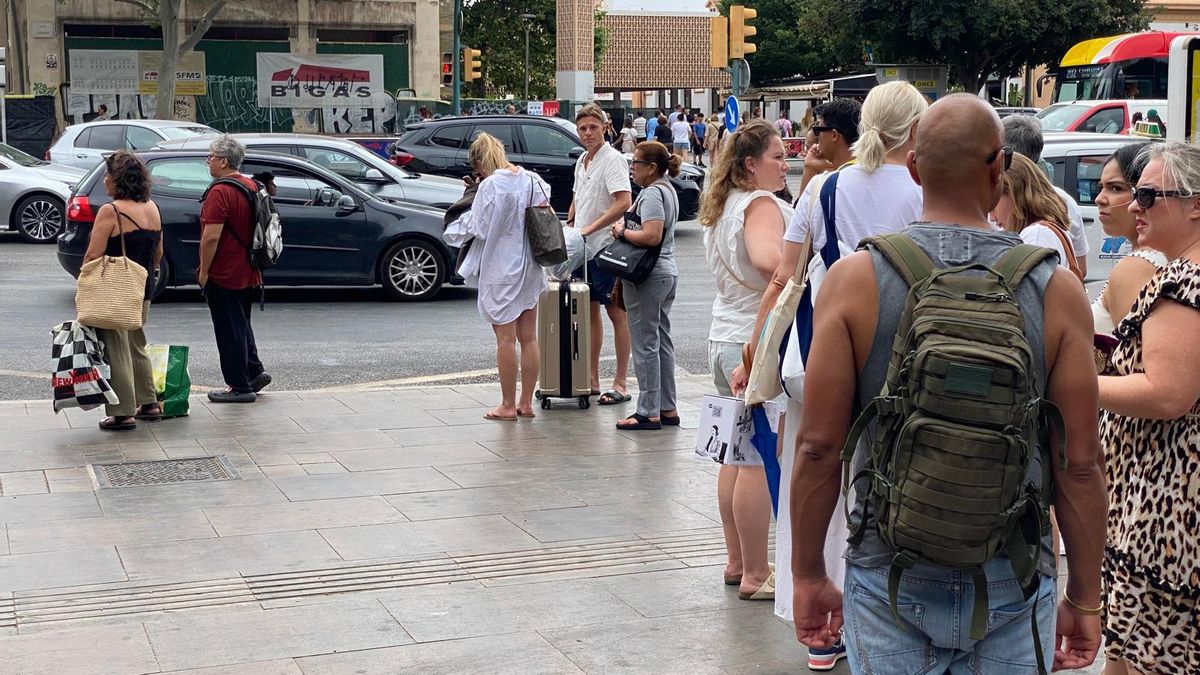 Ciudadanos esperan un taxi que no llega en la plaza de España