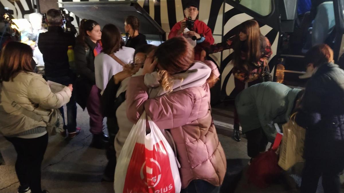 Dos chicas se abrazan tras la llegada del segundo bus de refugiados ucranianos a València