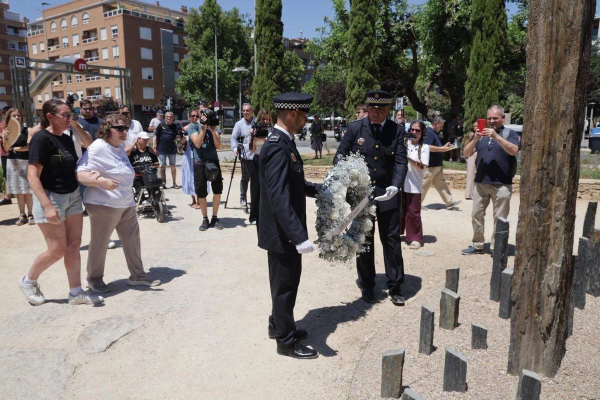 Los familiares y los agentes depositan la corona de flores.