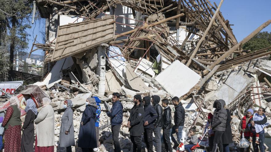 Un grupo de damnificados por los terremotos en Turquía hace cola para recibir ayuda alimentaria en la localidad de Kirikhan