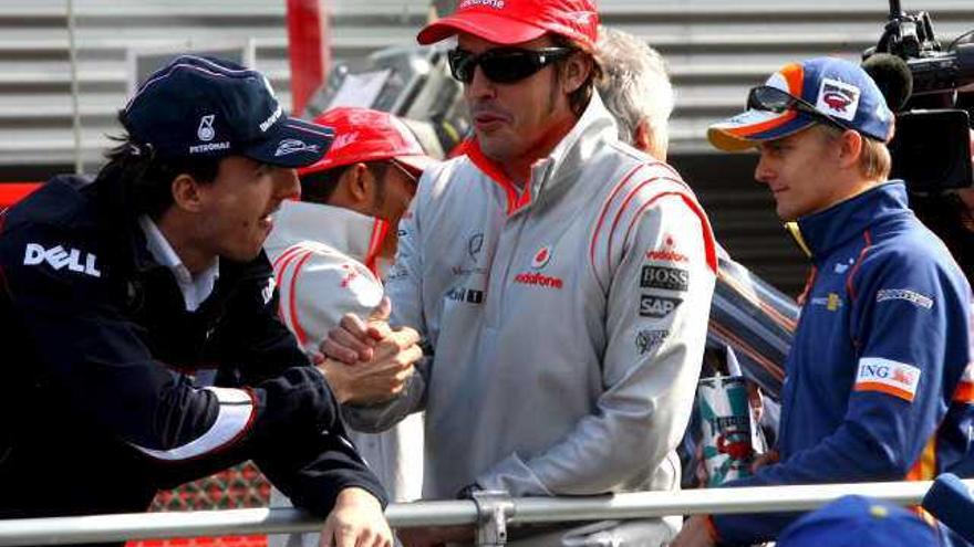 El piloto español de Fórmula Uno Fernando Alonso (c), de la escudería McLaren Mercedes, conversa con el piloto polaco Robert Kubica (izq), de BMW Sauber, durante el desfile de pilotos previo a la celebración del Gran Premio de Bélgica de Fórmula Uno disputado en el circuito Spa-Francorchamps