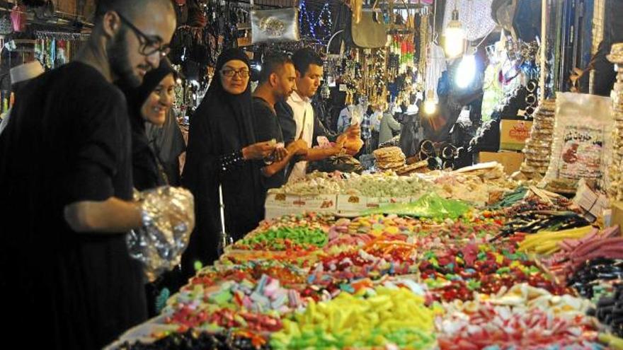 Palestins musulmans compren dolços en una de les parades de la ciutat vella de Jerusalem, al vespre