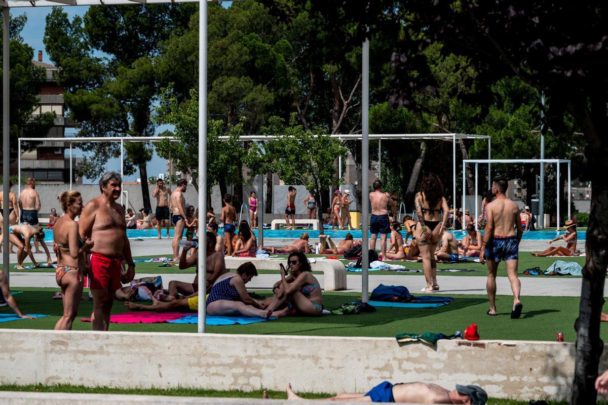 Varias personas disfrutan y se relajan en una piscina municipal en La Elipa (Madrid), intentando paliar la ola de calor de esta jornada.