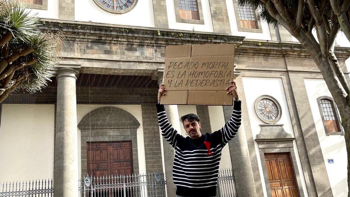 Alex Mercurio sostiene, ante la catedral de La Laguna, un cartel en el que se puede leer: "Pecado mortal es la homofobia y la pederastia"