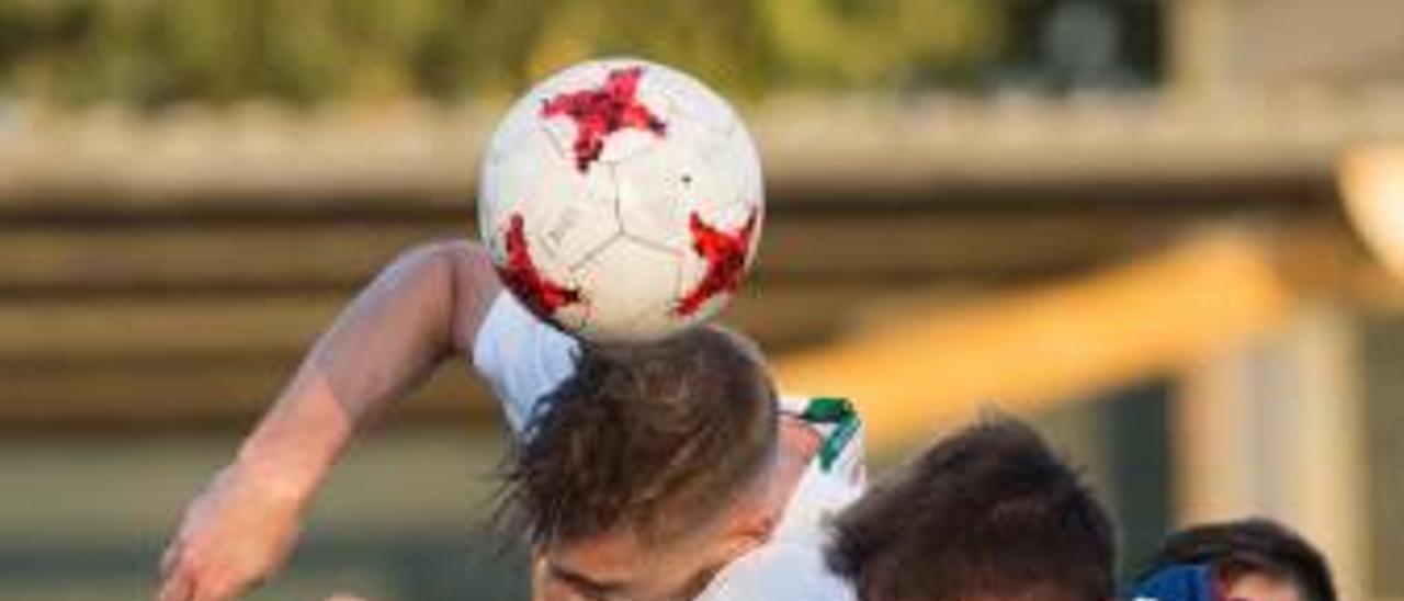 Adrián Jiménez salta por un balón con un jugador del Llagostera durante el partido del pasado sábado.