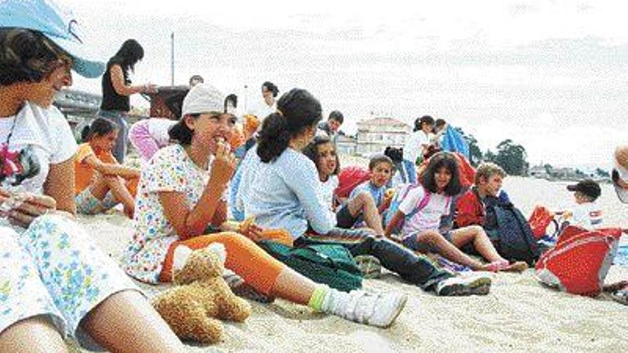 El grupo de niños del campamento de verano de Cangas, ayer en la playa de Rodeira. / G Nüñez