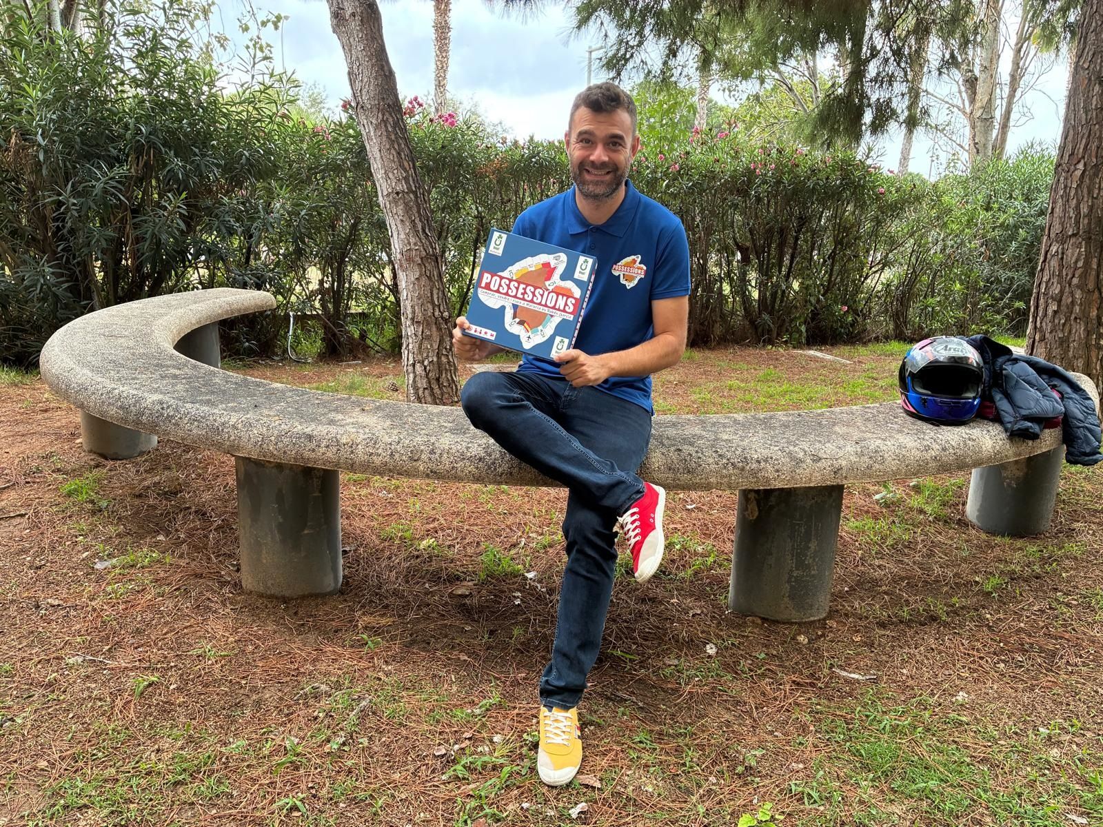 El cómico Rubén García sosteniendo su juego de mesa, 'Possessions'.