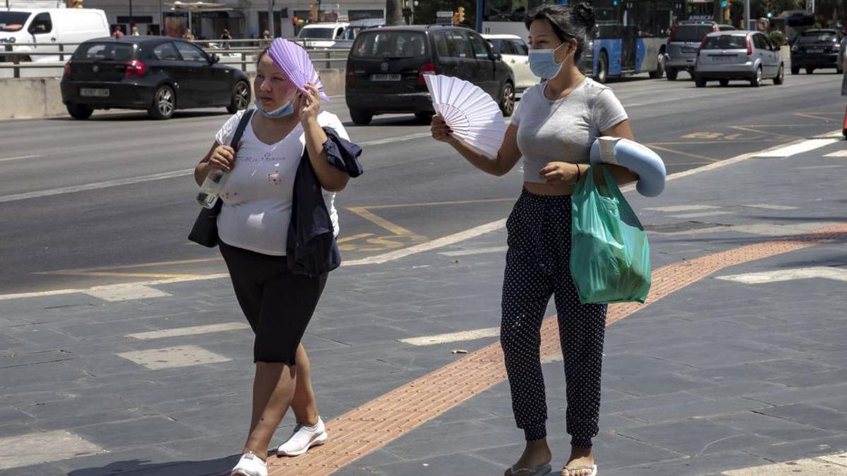 Dos mujeres se abanican para soportar el calor.