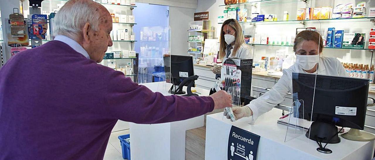 Un paciente recoge sus medicinas en una farmacia durante la pandemia, en foto de archivo.