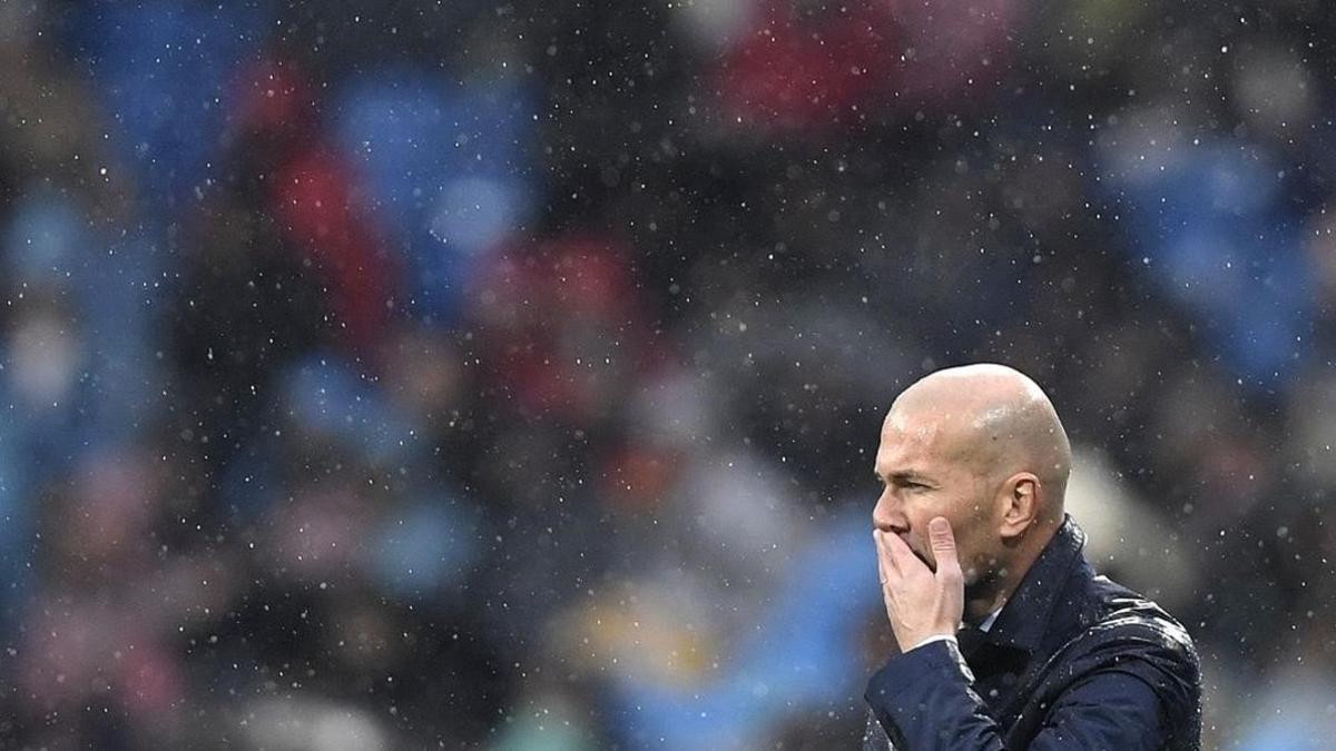 Zinedine Zidane medita bajo la lluvia en el estadio Santiago Bernabéu.