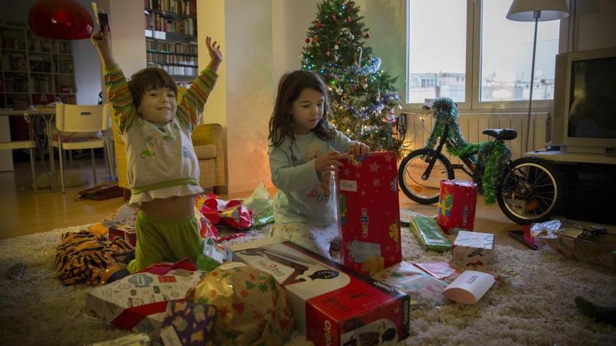 Niños abriendo sus regalos en la mañana de Reyes.