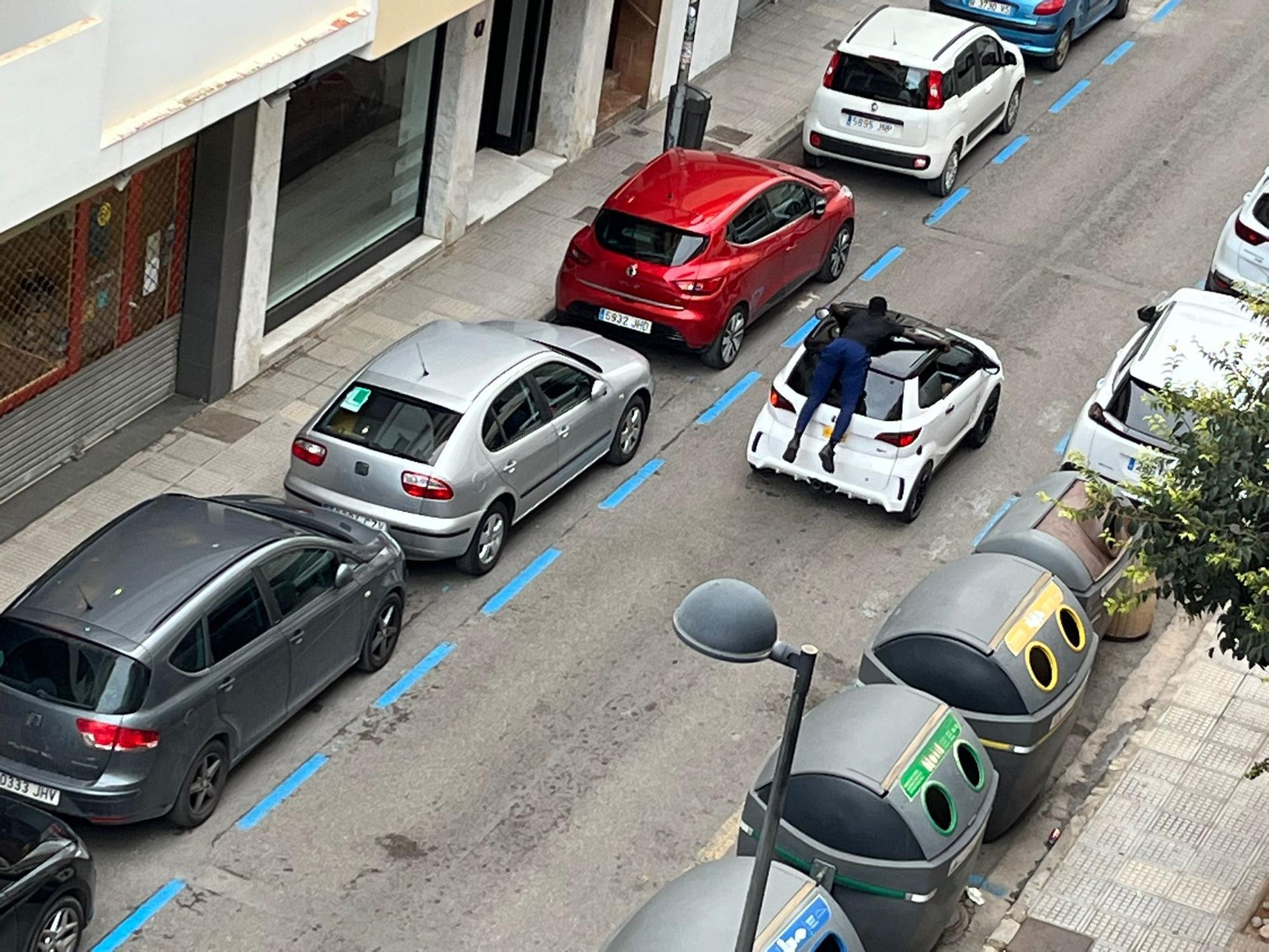 Un hombre pasea sobre el techo de un coche en Ibiza