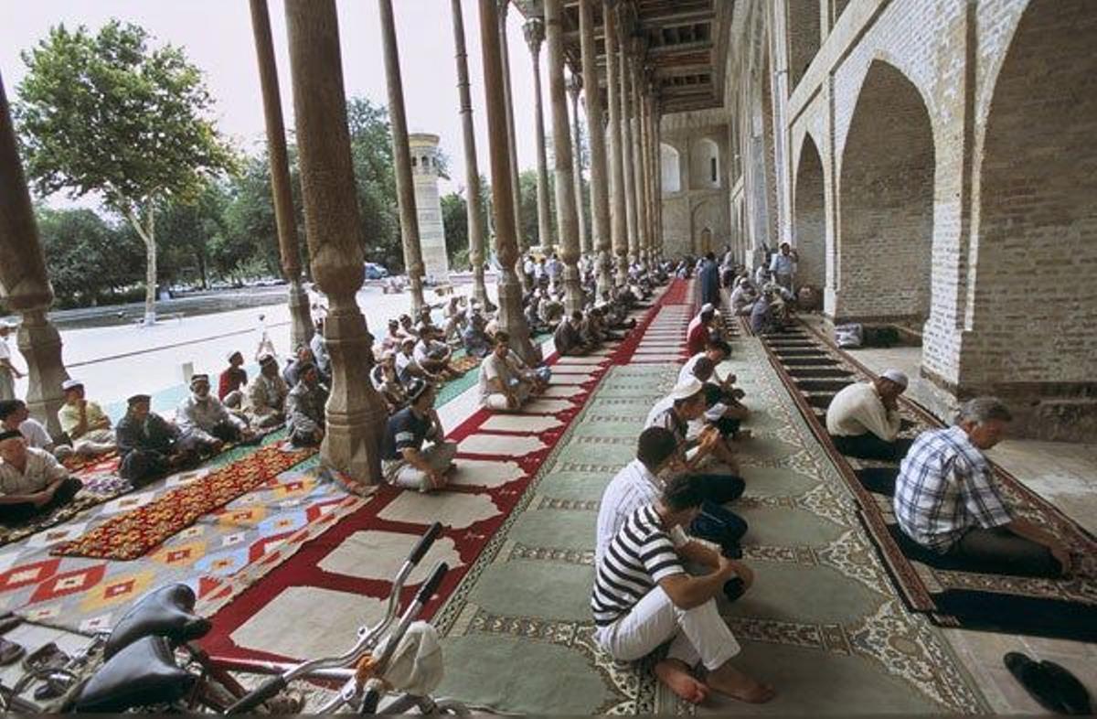 Hombres rezando en la mezquita Bolo Hauz de Bukhara.