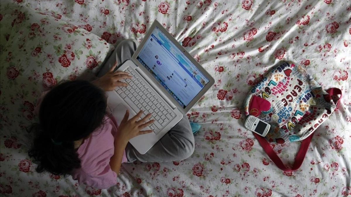 Una niña navega por internet desde su ordenador