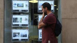 Anuncios de pisos en venta y alquiler en una oficina de Gràcia, en Barcelona.