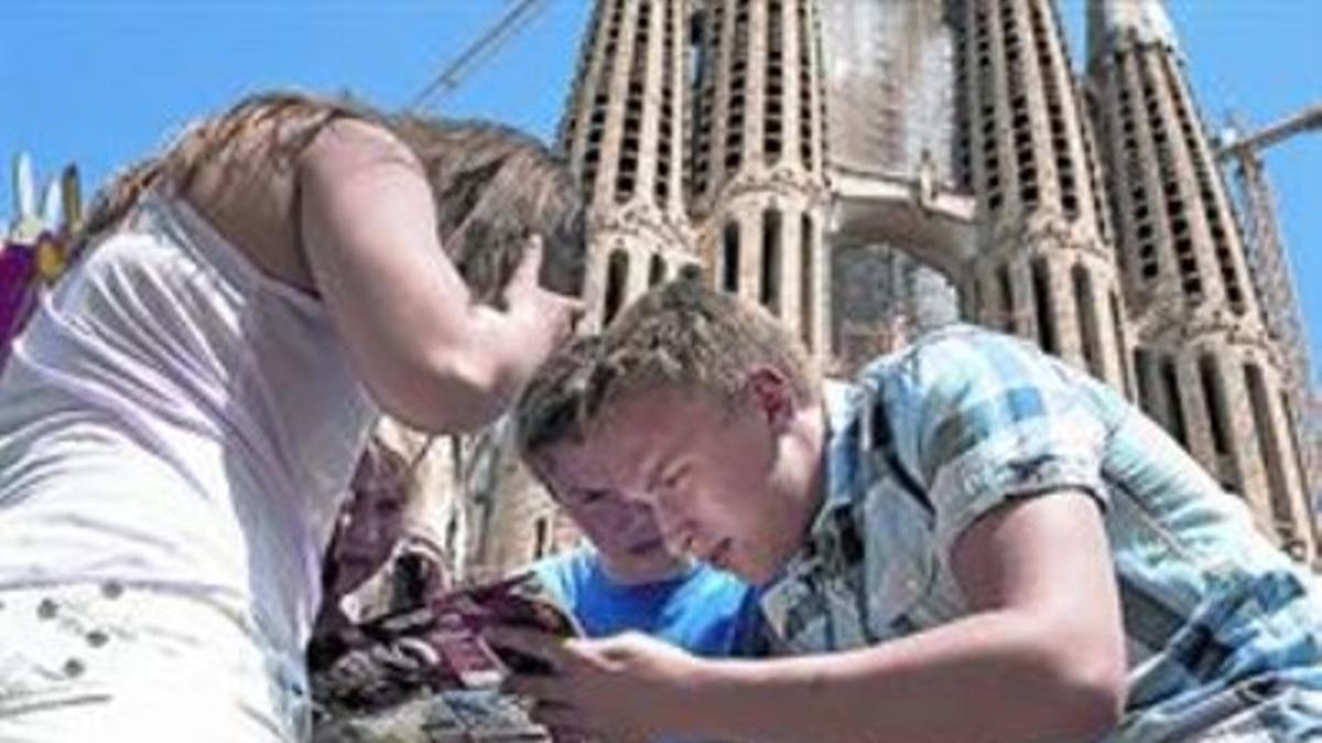 Turismo de Semana Santa 8 Una familia consulta un mapa ante la Sagrada Família, ayer.