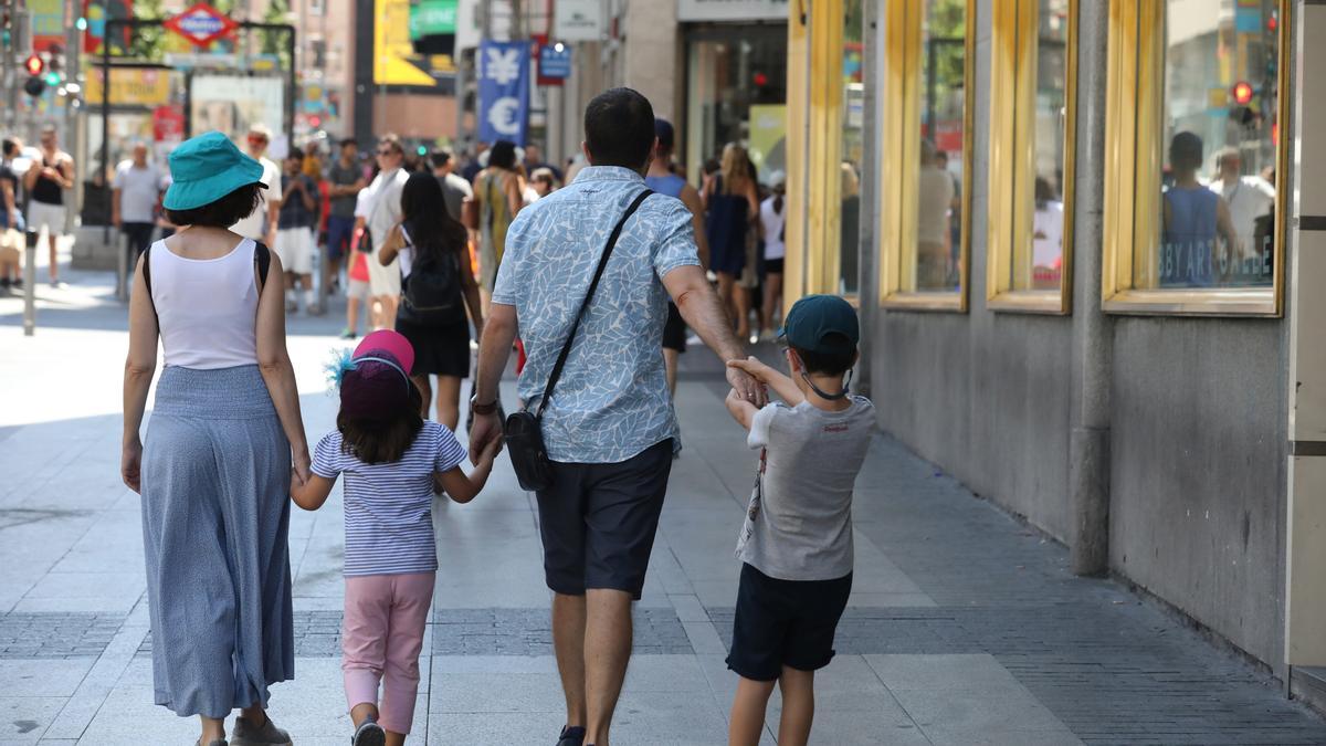 Archivo - Una familia pasea de la mano por una calle de Madrid