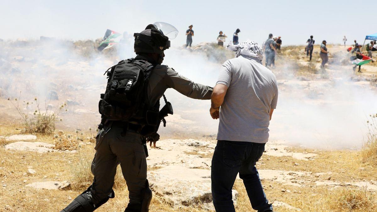 Un policía israelí carga contra un palestino.