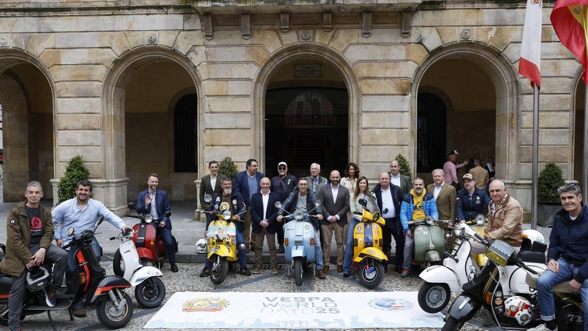 Autoridades y organizadores del evento, junto a sus vespas, frente al Ayuntamiento de Gijón, en la presentación.