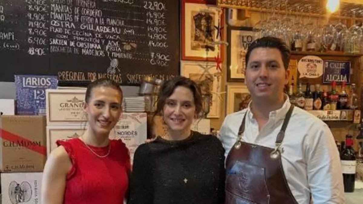 Los propietarios de la Tasca La Ultramarina posando con Isabel Díaz Ayuso en el interior del bar.