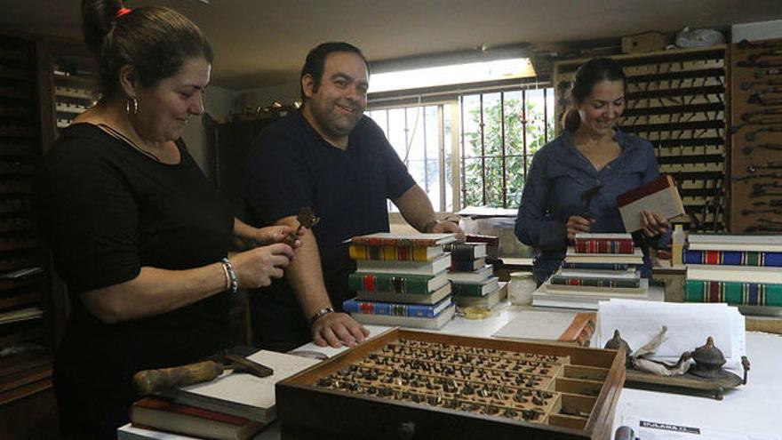 Rafael Cómitre y sus dos hermanas, en el taller donde obra el milagro.