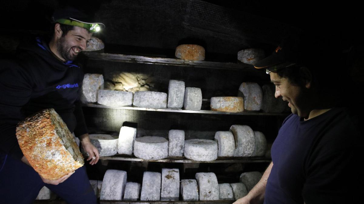 Rubén Remis, a la izquierda, con su hermano Enrique, en la cueva donde madura el queso.