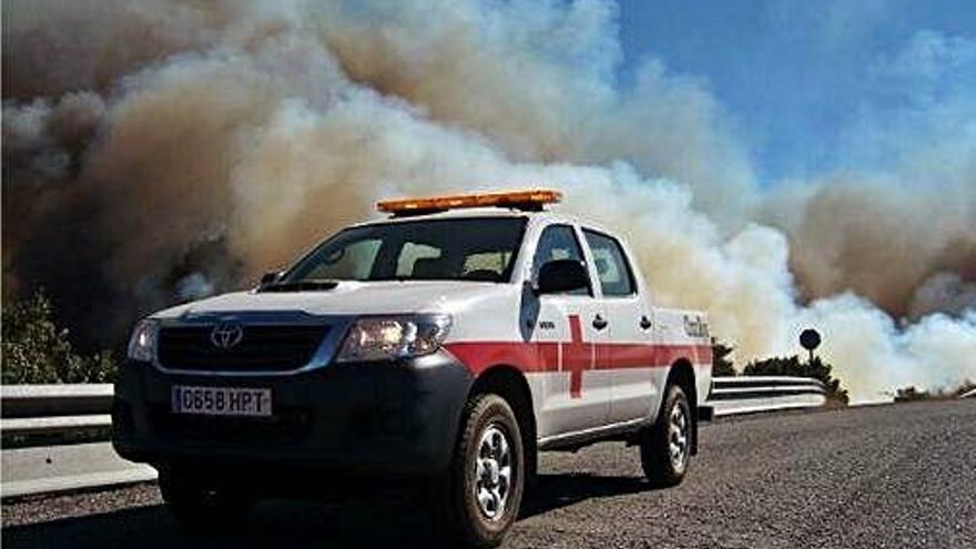 Un vehicle de la Creu Roja, a prop d&#039;una gran columna de fum a Gran Canària.