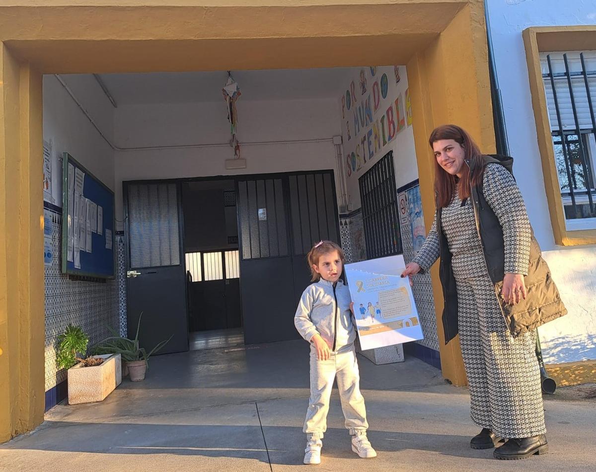 Lorena García, con su hija Gala, y el cartel de la carrera solidaria.