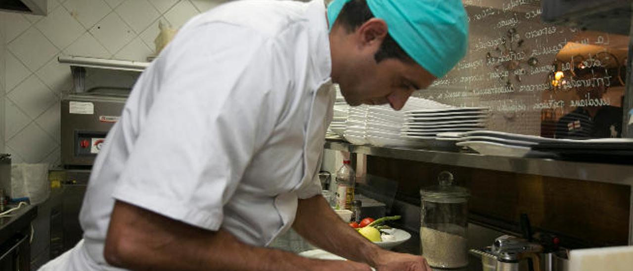 Un asalariado canario de la hostelería trabajando en una cocina.