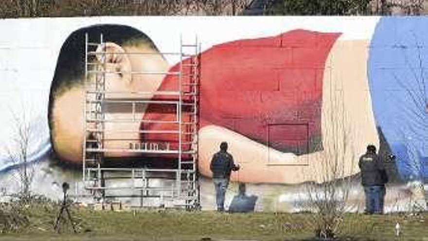 Los artistas trabajando en su grafiti en Fráncfort. // Efe