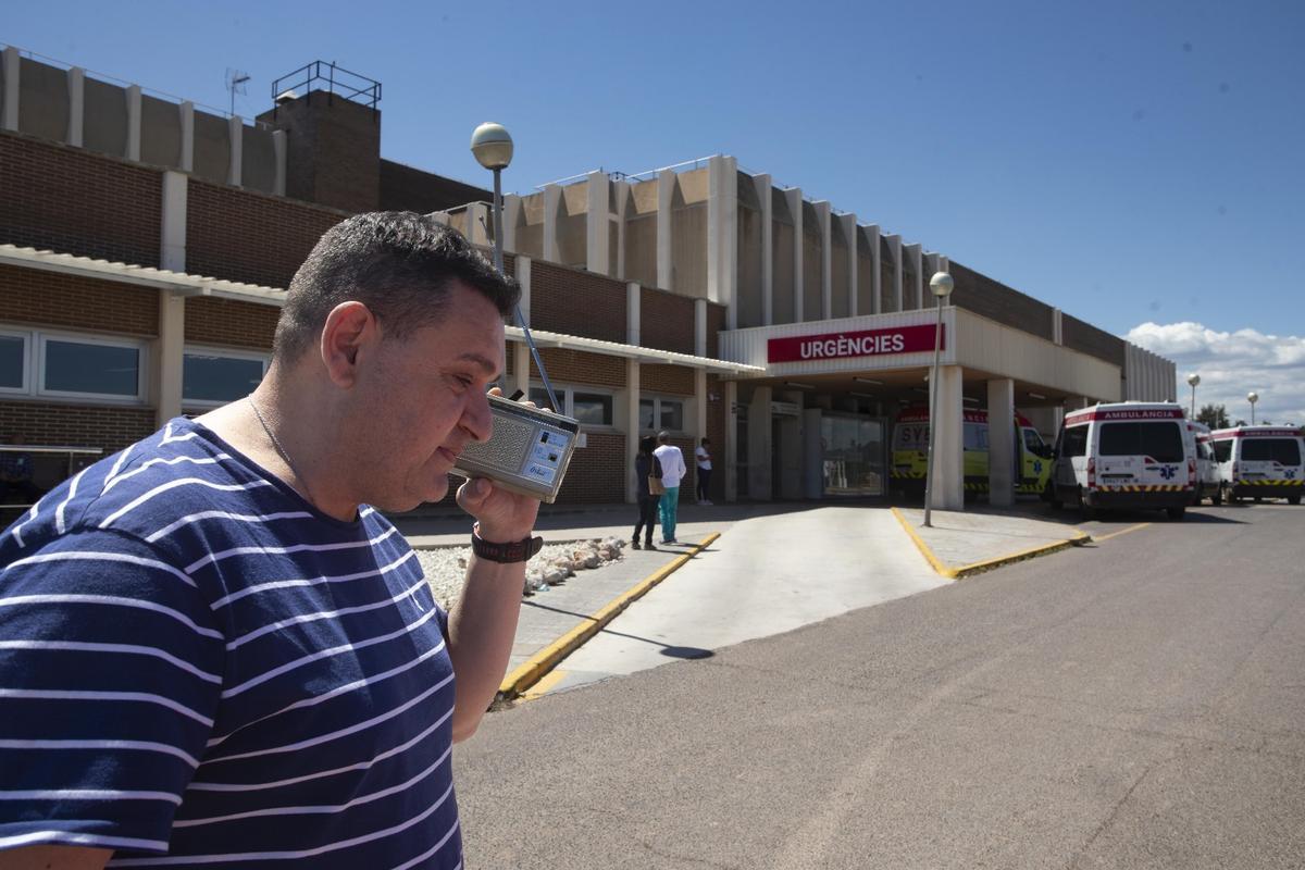 Una persona, intentando hablar frente al hospital, con varias ambulacias paradas.