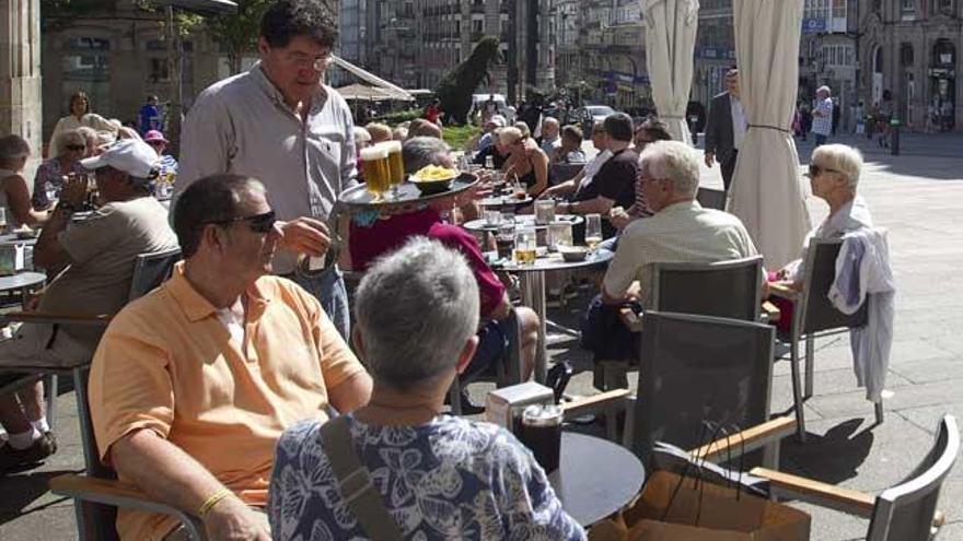 Un camarero atiende una terraza, en Vigo. // R. Grobas