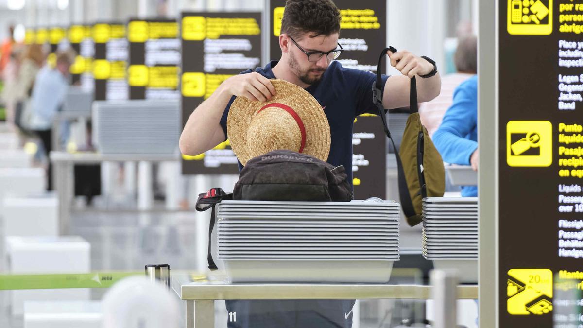 Un pasajero pasa el control de seguridad en el aeropuerto de Tenerife Sur.