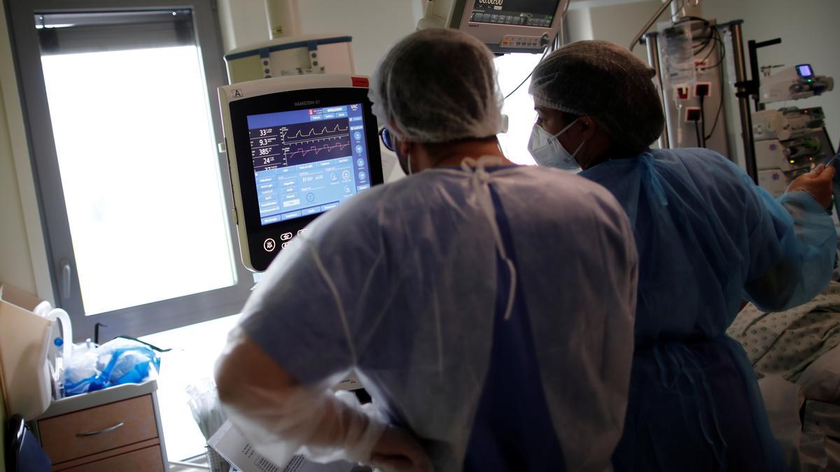 Dos trabajadores del hospital Melun-Senart, cerca de París, miran el monitor de un paciente de covid-19 ingresado en la uci.