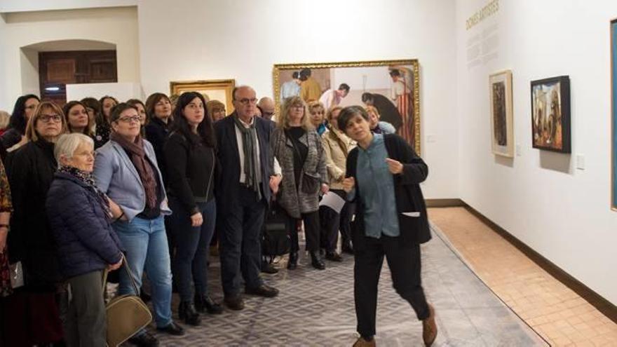 La guía explica a las personas visitantes la exposición de la Diputació de València.