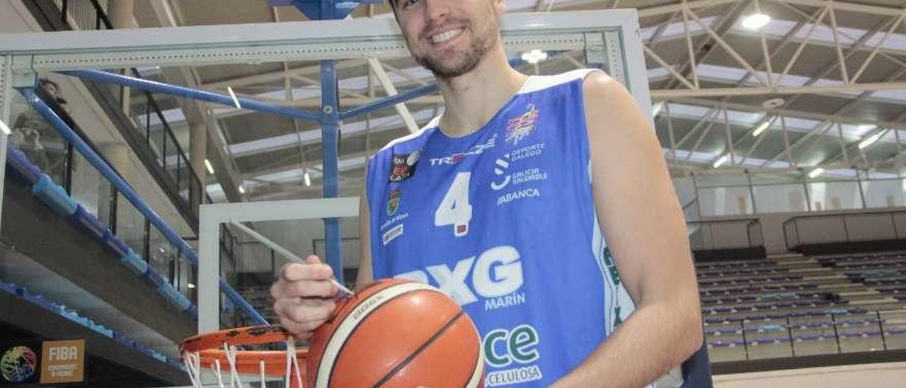 Juanchi Orellano, pintando un balón de baloncesto con un pincel. // Santos Álvarez