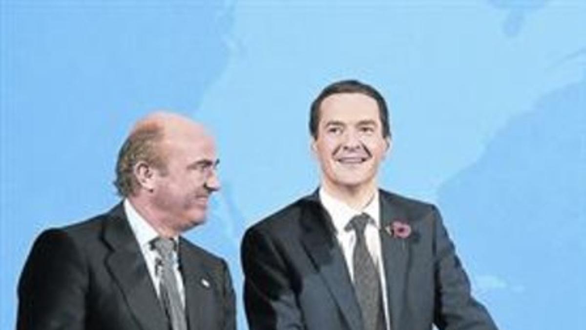 Luis de Guindos (izquierda) y el ministro británico George Osborne, tras una reunión de la OCDE contra la evasión fiscal, en Berlín el pasado 29 de octubre.