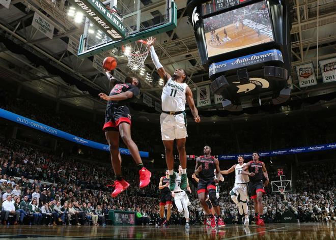 Montez Mathis, de los Caballeros Escarlata de Rutgers, dispara una bandeja mientras fue defendido por Aaron Henry # 11 de los Michigan State Spartans en la segunda mitad en Breslin Center, East Lansing, Michigan.