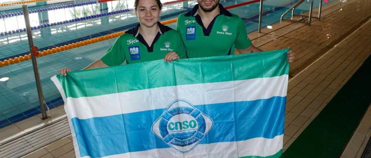 Los capitanes Alba Ortiz de Guinea y Mario Cortés sujetan una de las banderas del Santa Olaya.