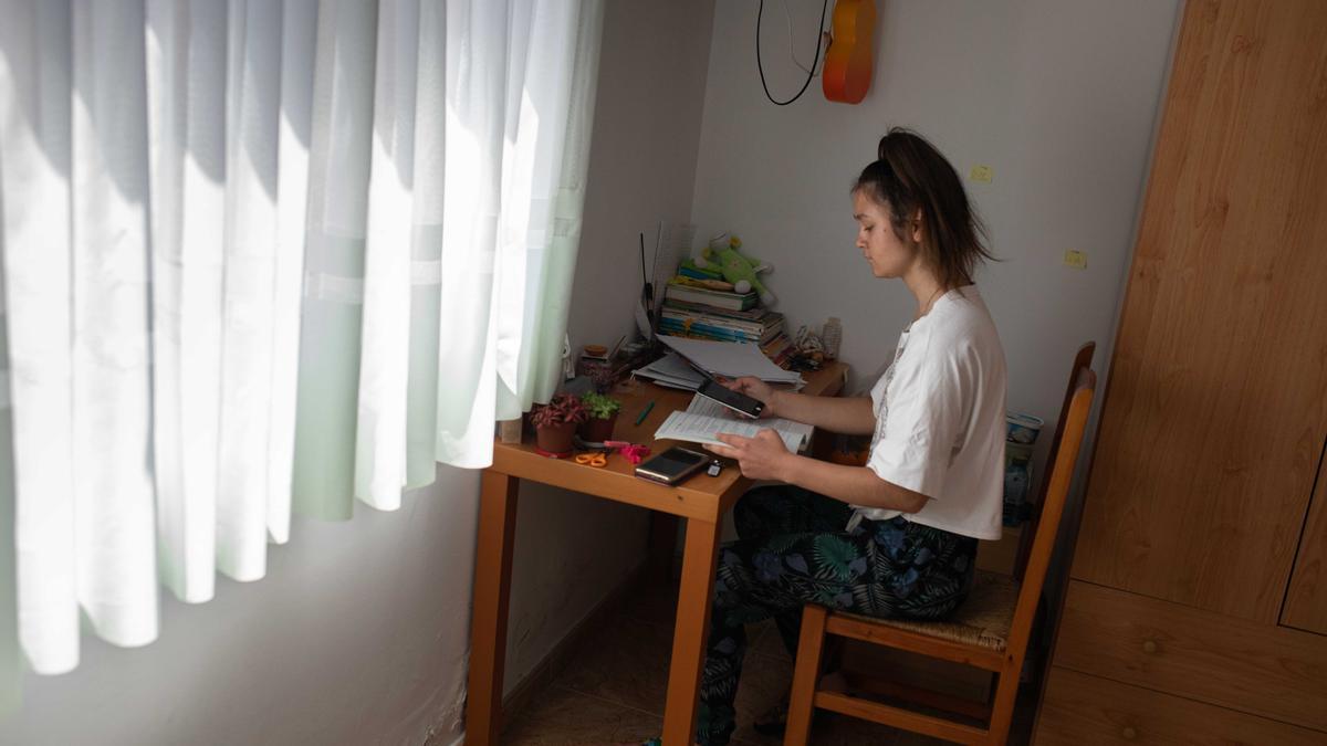Elina sigue sus clases online de Ucrania a través del móvil en su habitación del hostal, su nueva casa. 