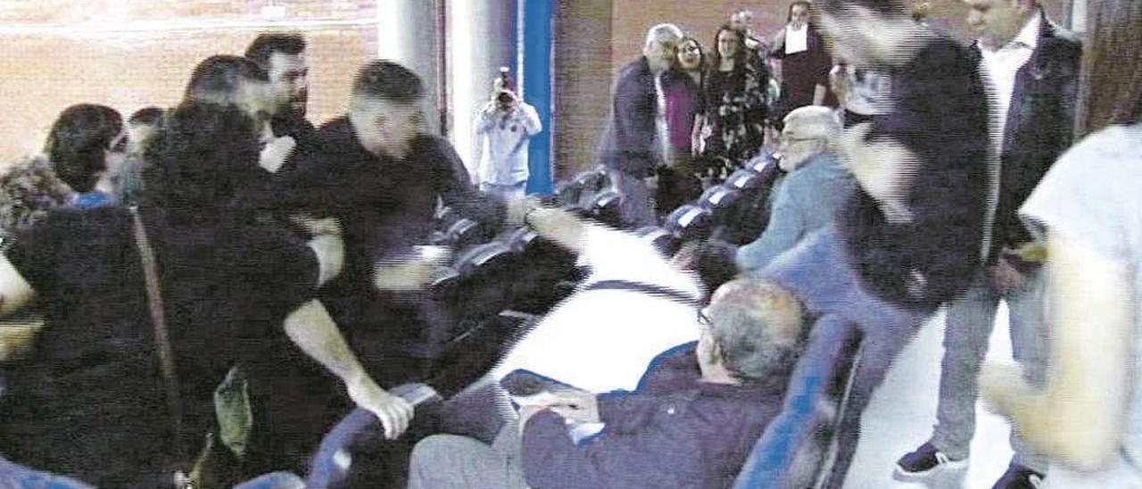 Momento en el que el policía local de Cangas (en el suelo, con camiseta blanca) recibe una patada en la espalda durante la asamblea de Anova. // Imagen cedida por la TVG