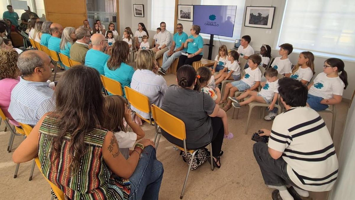 Óscar Vázquez, Daniel Pérez e Belén Lendoiro, sentados á dereita entre os nenos e nenas que representaron no acto as 18 parroquias de Carballo.
