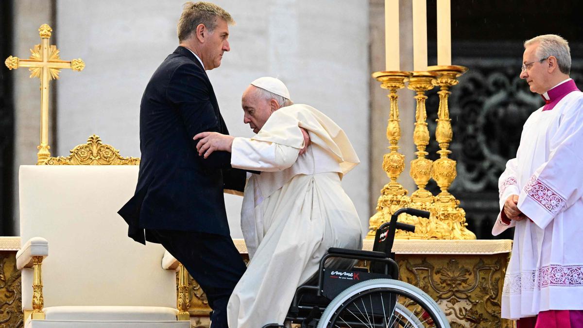 El ayudante del Papa, Sandro Mariotti ayuda al Papa Francisco a levantarse de su silla de ruedas en la misa de beatificación del difunto Papa Juan Pablo,  en la plaza de San Pedro en el Vaticano.