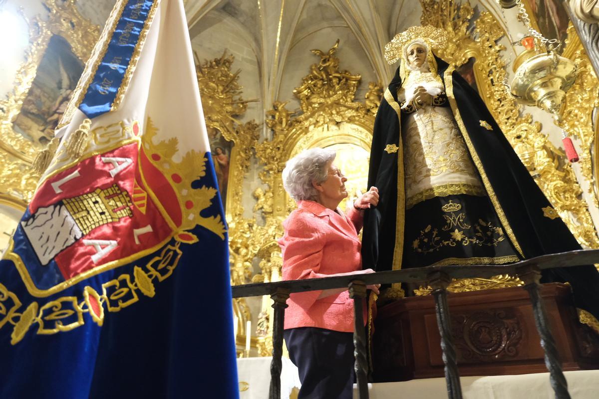 Las hermanas de la cofradía colocan el manto a la virgen.