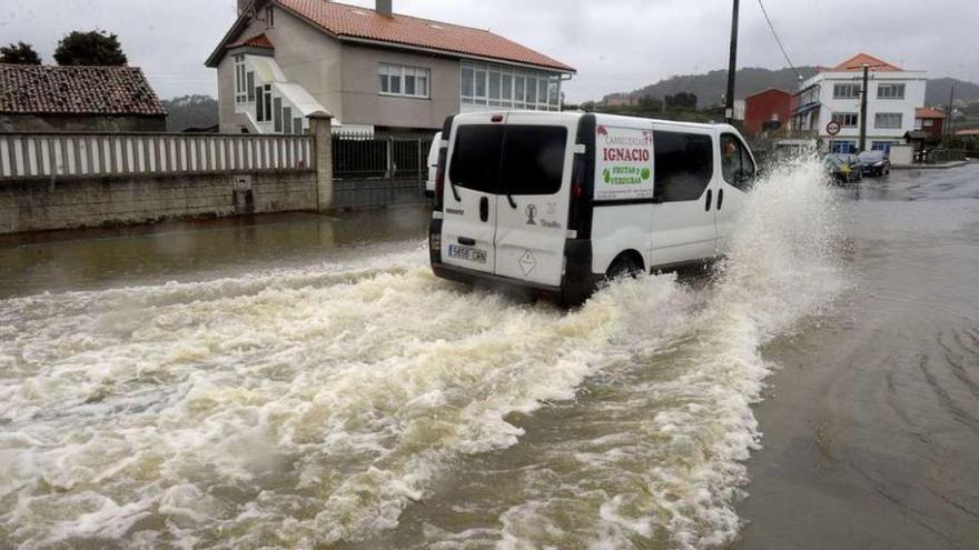 Una furgoneta circula por una carretera inundada en Barrañán.