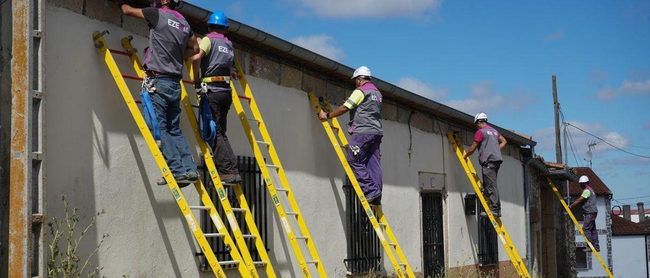Operarios despliegan cable para conectar una vivienda en un pueblo de Zamora.