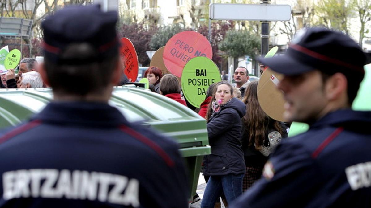 Dos agentes de la Ertzaintza custodian la vivienda del diputado del PP José Eugenio Azpiroz, el lunes en San Sebastián.