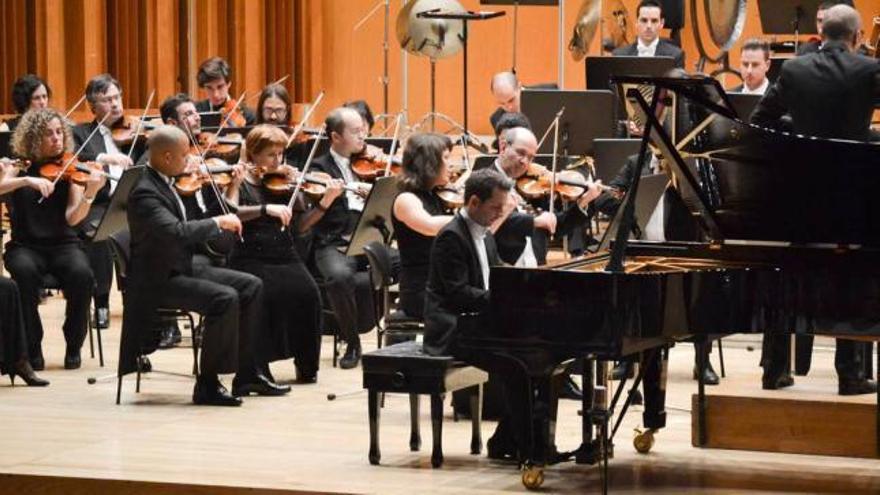 Bertrand Chamayou, al piano, con la orquesta Oviedo Filarmonía y Marzio Conti de espaldas.