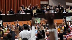 Diputados de la Asamblea Nacional de Cuba ejercen su derecho al voto durante la sesion plenaria celebrada el 22 de diciembre en el Parlamento, en La Habana.