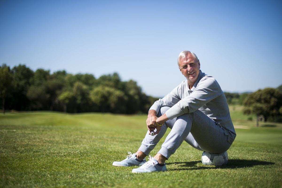 Johan Cruyff fotografiado sobre un balón sobre el hoyo 18 del campo de golf de El Muntanya.